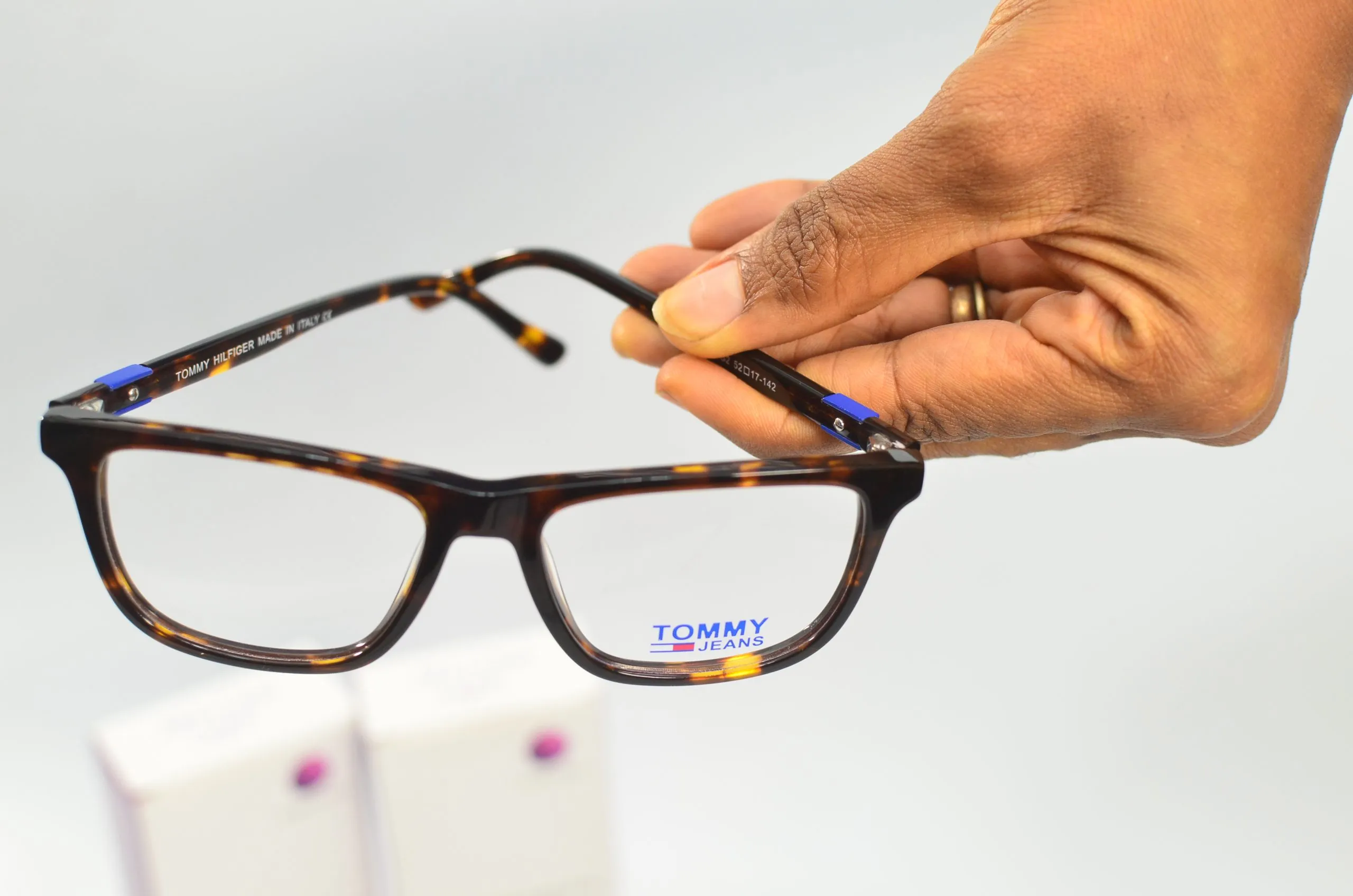 Close-up of a hand holding a pair of prescription glasses frames